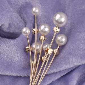 Broche bouquet de fleurs dorée avec perles brillantes sur fond luxueux en velours violet