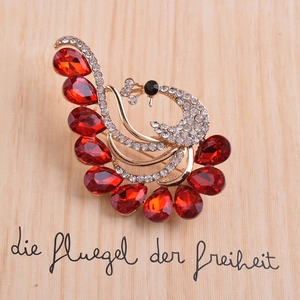 Spilla pavone elegante in lega dorata con piume di cristallo rosso e strass bianchi