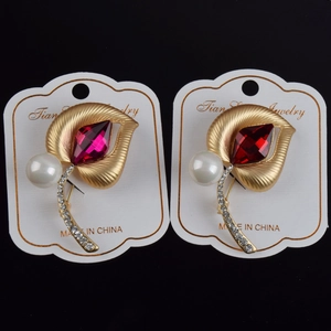 Detalle de broche de hoja con gema roja, perla blanca y cristales brillantes