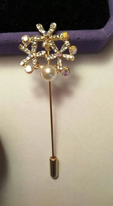 Broche fleur dorée élégante avec perle blanche et cristaux sur longue épingle de sûreté