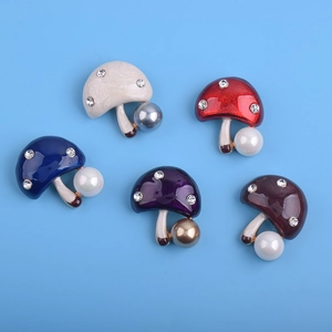 Détail macro de broches champignons colorées avec fini brillant et décor perle sur tige