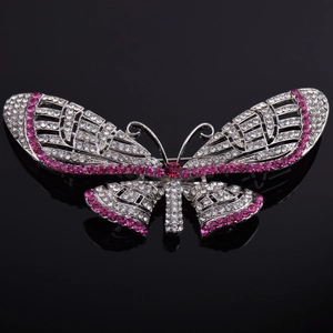 Macro view of silver butterfly brooch with pink crystals and rhinestones on black glass
