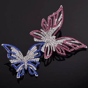 Détail de broches papillon en alliage avec strass roses et bleus sur fond noir
