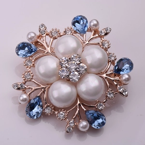 Détail de broche fleur avec cristaux bleus en goutte et perles sur monture or rose