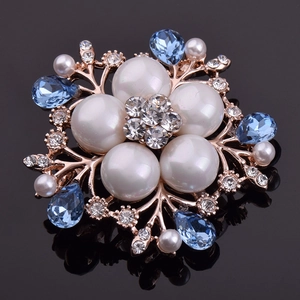 Broche florale avec perles et cristaux bleus sur base or rose, accessoire élégant