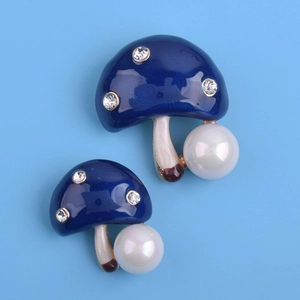 Détail de broche champignon avec émail bleu foncé, strass brillants et perle blanche