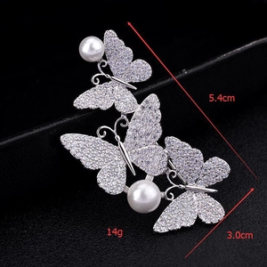 Macro shot of silver butterfly brooch with sparkling zircons and pearl details