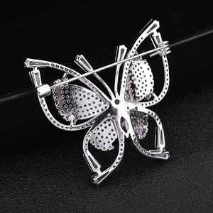 Macro view of butterfly brooch silver metal back showing pin fastener and detailed setting