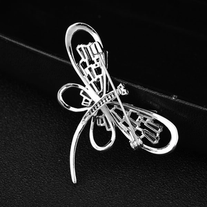 Broche libellule argentée avec zircone AAA montrant le fermoir au dos sur du cuir noir