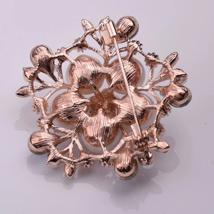 Vue détaillée du dos de la broche fleur en or rose avec fermoir épingle de sécurité