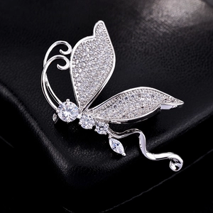 Elegant silver butterfly brooch with micro-paved zircons on black textured background