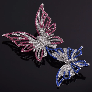 Broches papillon étincelantes avec strass colorés sur un fond noir réfléchissant