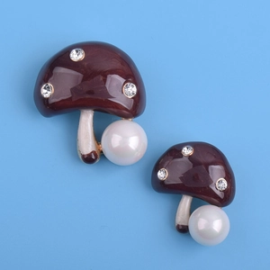 Détail de la broche champignon avec émail marron, strass et perles blanches rondes