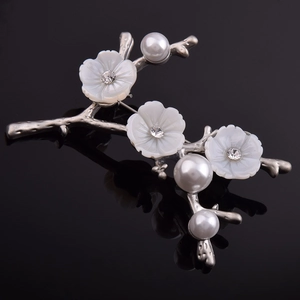 Broche vintage élégante avec fleurs en nacre et perles sur une branche argentée