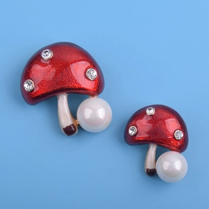 Détail de la broche champignon en émail rouge avec zircons et perle élégante