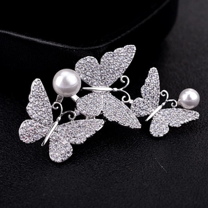 Luxury butterfly brooch with sparkling cubic zirconia and pearls on elegant black background