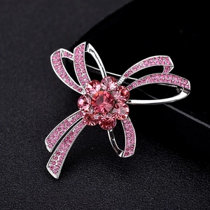 Broche nœud argentée élégante avec cristaux roses autrichiens et motif floral précieux