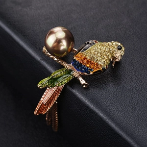 Broche perroquet exquise avec strass colorés et perle brune sur fond de cuir noir texturé