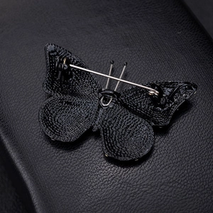 Exquisite black butterfly brooch back view showing secure silver pin on metal base