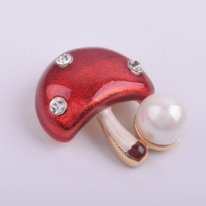 Détail de la broche champignon en émail rouge avec perle blanche et cristaux