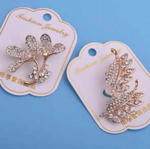 Ensemble de broches dorées en forme de fleurs et plumes avec strass étincelants
