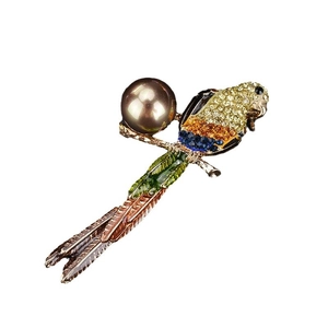 Broche perroquet colorée avec cristaux et perle marron sur fond blanc épuré