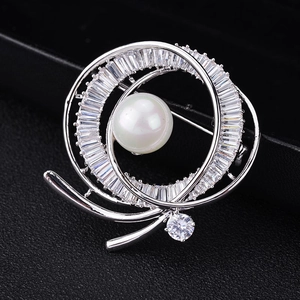 Dettaglio macro della spilla in argento con perla bianca e zirconi cubici per eleganza