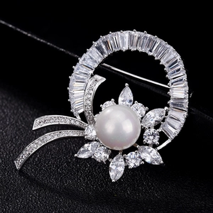 Broche élégante en perles et zircons scintillants sur fond en cuir noir texturé