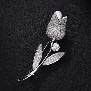 Elegante spilla a tulipano in metallo argento con micro zirconi e un accento di perla bianca