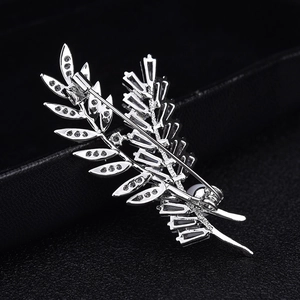 Élégante broche feuille de blé argentée avec zircons et perle blanche sur fond noir