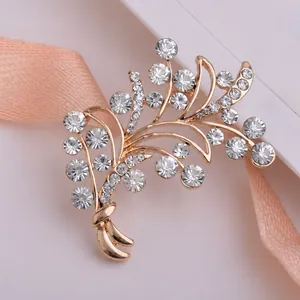 Macro d'une broche florale dorée avec cristaux étincelants sur une carte à bijoux