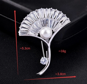 Close-up of fan-shaped silver brooch with micro-pave zircons and a large white pearl center