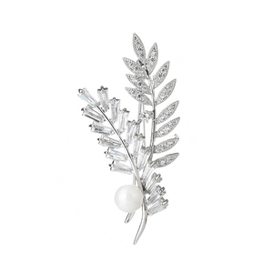 Élégante broche feuille en argent avec zircons micro-pave et perle blanche sur fond blanc