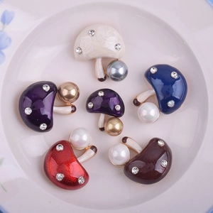 Broches champignons mignonnes avec perles, émail coloré et strass sur une assiette