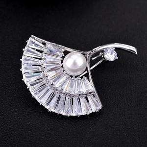 Elegant silver fan-shaped brooch with baguette-cut cubic zirconia and a round pearl