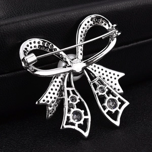 Detailed back view of the bow brooch showing the silver clasp and intricate hollow metalwork