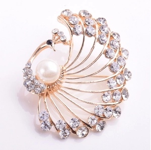 Detailed close-up of peacock brooch with sparkling rhinestones and white pearl