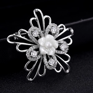 Elegant shell flower brooch with AAA cubic zirconia and white pearl on black stand