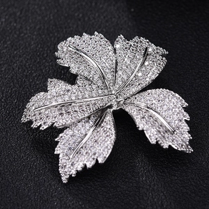 Exquisite maple leaf brooch in silver-tone metal with sparkling zircon inlay on black leather