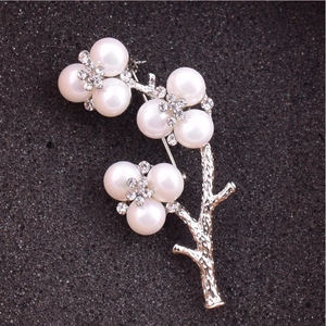 Macro detail of elegant flower branch brooch with imitation pearls and sparkling rhinestones