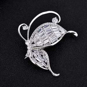 Exquisite silver butterfly brooch with baguette-cut zircons on a textured black background