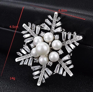 Detailed size view of snowflake brooch with pearls and cubic zirconia on black background