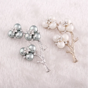 Close-up of pearl flower brooches with rhinestones and textured metal branches