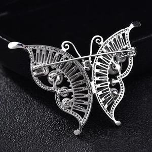 Elegant hollow butterfly brooch with white pearls and rhinestones on black display