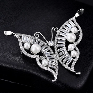 Elegant silver butterfly brooch with white pearls and sparkling zircons on black leather