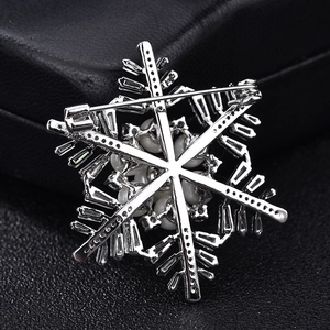 Elegant silver snowflake brooch with pearls and zircons for Christmas on black leather