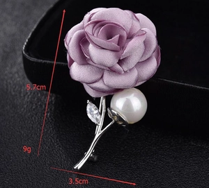 Detailed view of purple fabric rose brooch with size dimensions 5.7cm by 3.5cm