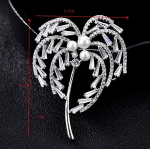 Macro d'une broche palmier avec zircons, perles et dimensions de taille précises