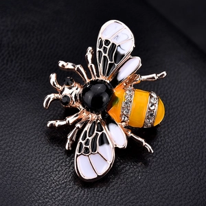 Détail d'une broche abeille avec émail jaune et strass brillants sur fond noir