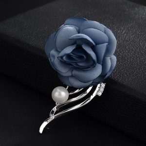 Close-up of navy blue fabric rose brooch with silver metal base, pearl and zircon detail